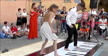 Couple Plays Floor Piano with Synchronized Dance