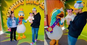 Baby Clings to Donald Duck’s Hand in Precious Moment